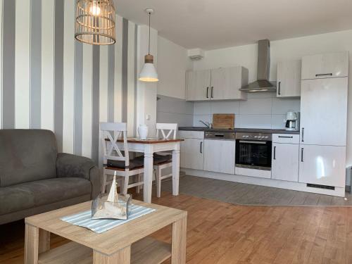 Il dispose d'une cuisine et d'un salon avec un canapé et une table. dans l'établissement Kleine Brise Apartment 5, à Büsum