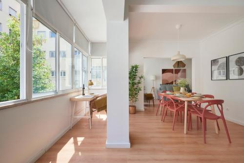 a kitchen and dining room with a table and chairs at Sunset Balcony Apartment, By TimeCooler in Lisbon