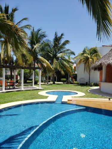 a swimming pool in a yard with palm trees at VILLA ACAPULCO DIAMANTE in Acapulco