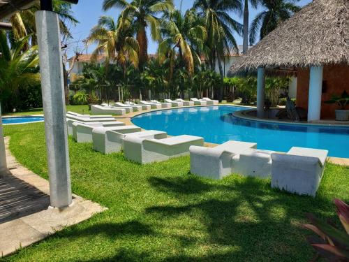 a swimming pool at a resort with palm trees at VILLA ACAPULCO DIAMANTE in Acapulco