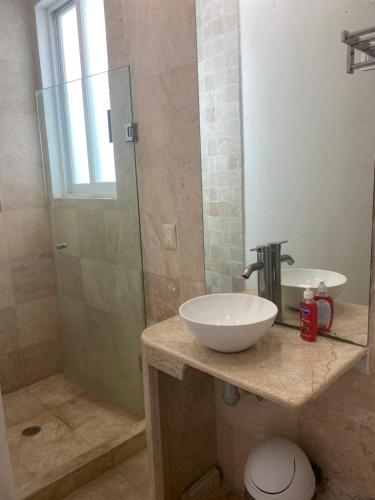 a bathroom with a sink and a glass shower at VILLA ACAPULCO DIAMANTE in Acapulco