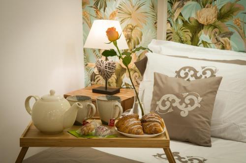 een dienblad met gebak op een tafel naast een bed bij Loft del Teatro in Siracusa