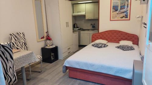 a small bedroom with a bed and a kitchen at Apartment Rosse in Split