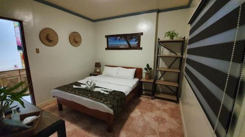 a bedroom with a bed and a book shelf at UNK'S HOUSE HOMESTAY in Panglao