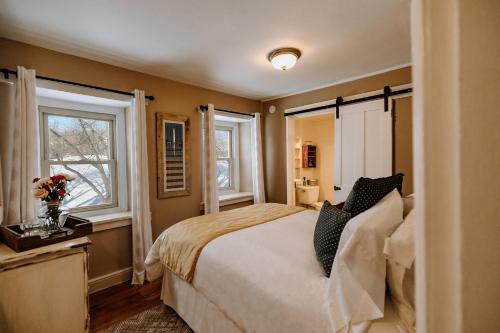 a bedroom with a large bed and two windows at Galvanized America Inn & Art Gallery in Doylestown
