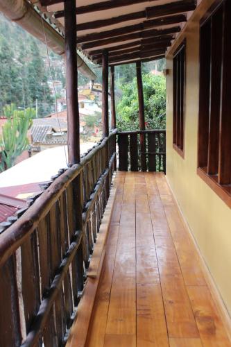 a wooden walkway leading to the balcony of a house at Hostal Iskay in Ollantaytambo