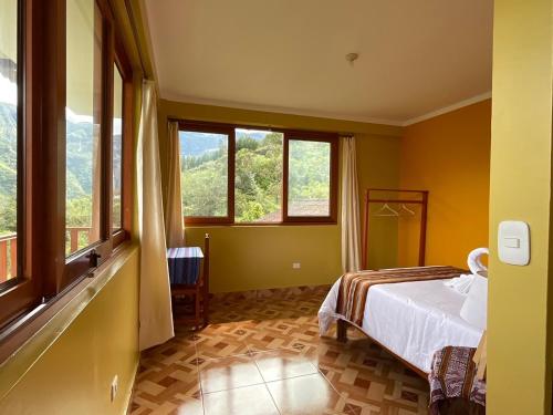 a bedroom with a bed and two windows in it at La Rivera de Gocta in Cocachimba