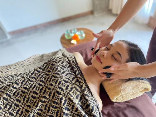 a woman getting her hair brushed by a beautician at Kastara Resort in Ubud