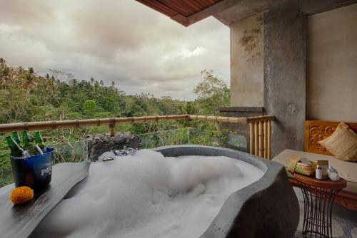 a bath tub filled with snow on a balcony at Kastara Resort in Ubud