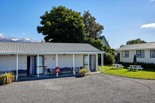a house with a porch and a yard at Alpine View Motel in Kaikoura