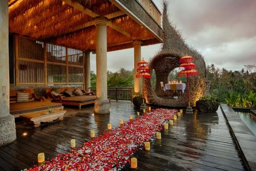 a lobby with a bunch of red flowers on the floor at Kastara Resort in Ubud