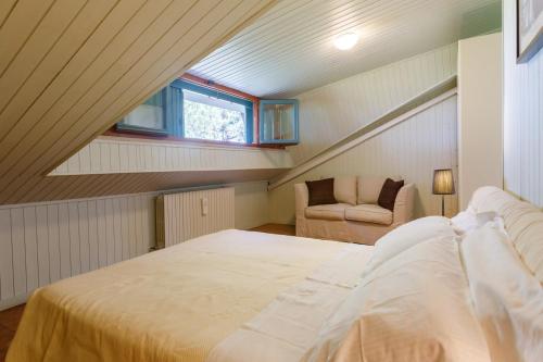 1 dormitorio en el ático con cama y ventana en Villa Rosaria by Mmega, en Ripe