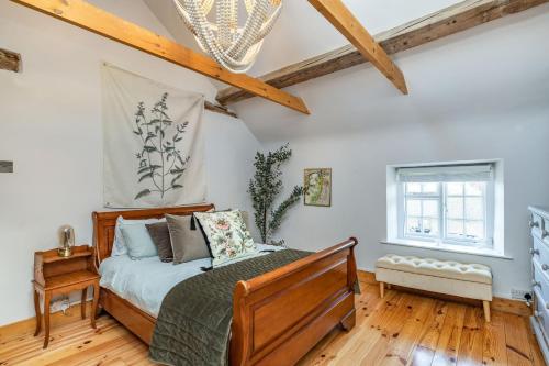 a bedroom with a bed and wooden floors at 4 Canalside Cottages in Towcester