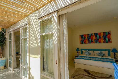 レギャンにあるAwila Villas Kutaのベッドルーム1室(ベッド1台、ガラスドア付)