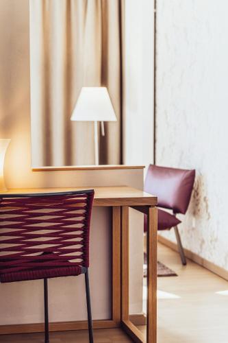 a table with two chairs and a lamp on it at Hotel Birkenhof in Bad Radkersburg