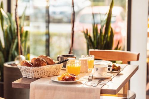 a table with a breakfast of bread and orange juice at Hotel Birkenhof in Bad Radkersburg