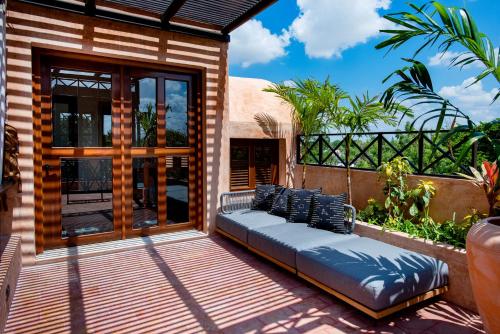 a patio with a couch on a deck at CIGNO HOTEL BOUTIQUE- Adults Only in Mérida