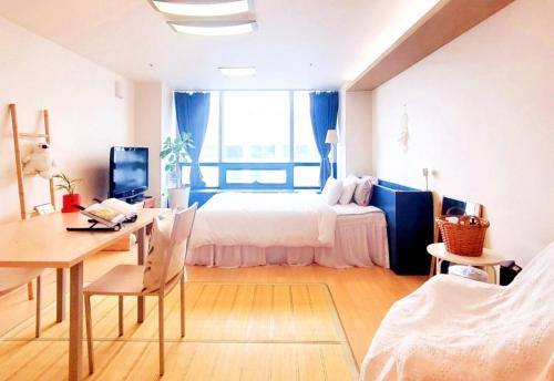 1 dormitorio con 1 cama y escritorio con ordenador en Cozy - Experience Home like Comfort Studio en Incheon