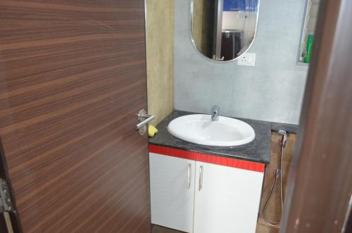 a bathroom with a sink and a mirror at Oviyam Sea view Apartment, feel like home in Chennai