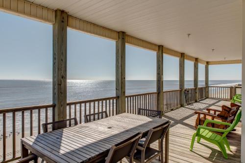 een veranda met een tafel en stoelen en de oceaan bij Marisol - PET FRIENDLY and Gulf Front! Enjoy the large deck with amazing views! home in Dauphin Island