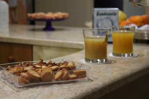 two glasses of orange juice and a tray of nuts at Hotel Il Giardino degli Aranci in Nola