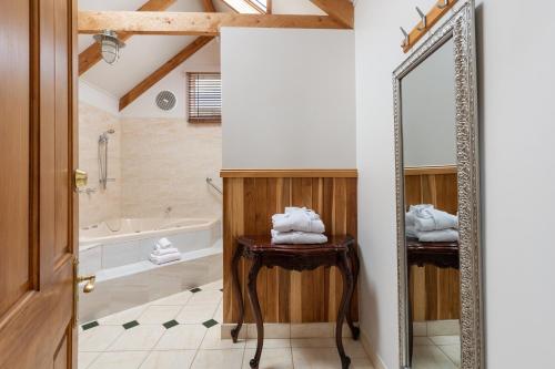 a bathroom with a tub and a mirror at Ellie's Cottages in Stanley