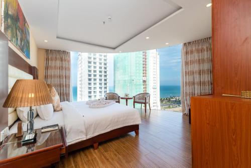 a bedroom with a bed and a view of the ocean at Nhat Minh Hotel and Apartment in Da Nang