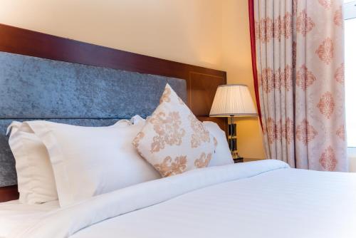 a bedroom with a bed with white sheets and pillows at Nhat Minh Hotel and Apartment in Da Nang
