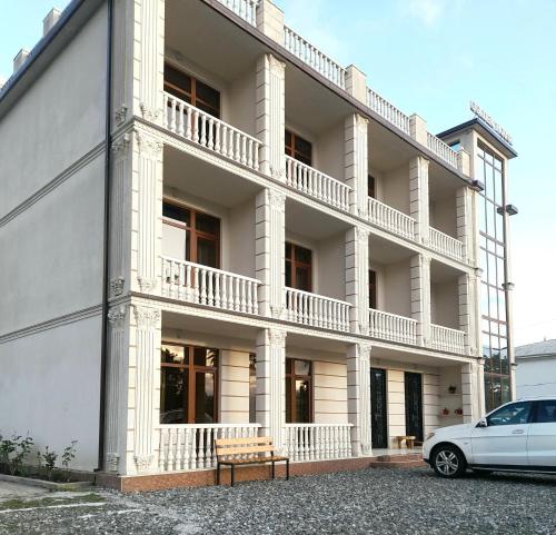 a white building with a car parked in front of it at Golden House in Anaklia