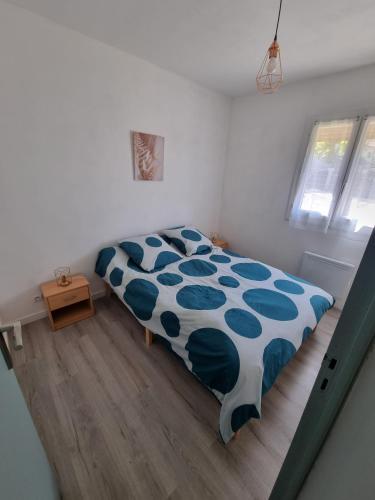 une chambre avec un lit avec une couette bleue et blanche dans l'établissement location vacances T4 bas de villa Toulon, à Toulon