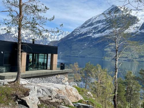 a house on a cliff with a view of a mountain at VILLA KRISTINA / ÅNDALSNES in Torvik