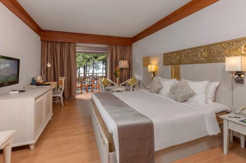 a bedroom with a large bed and a living room at Best Western Premier Bangtao Beach Resort & Spa in Bang Tao Beach