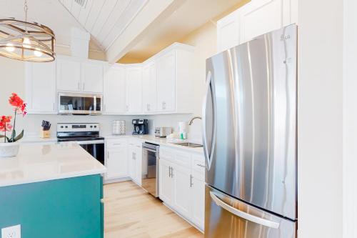 a kitchen with white cabinets and a refrigerator at On Deck in Dauphin Island