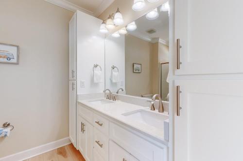 a bathroom with two sinks and a large mirror at On Deck in Dauphin Island