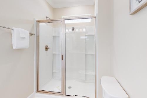 a shower with a glass door in a bathroom at On Deck in Dauphin Island
