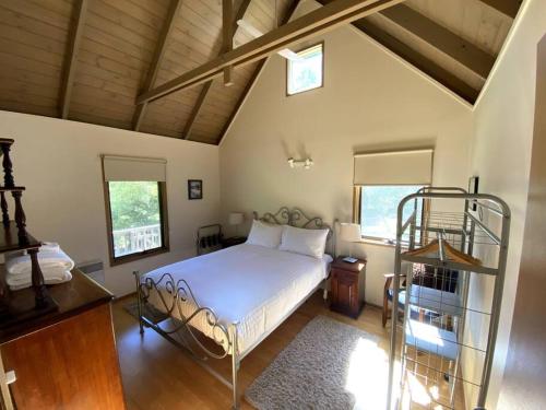 1 dormitorio con cama blanca y techo de madera en Crabapple Cottage Harrietville, en Harrietville
