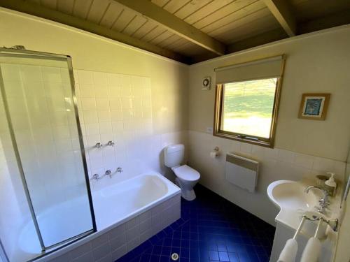 y baño con bañera, aseo y lavamanos. en Crabapple Cottage Harrietville, en Harrietville