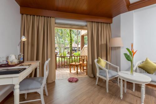 a living room filled with furniture and a window at Best Western Premier Bangtao Beach Resort & Spa in Bang Tao Beach