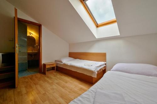 a bedroom with two beds and a skylight at Penzión a Reštaurácia u Jeleňa in Stará Ľubovňa
