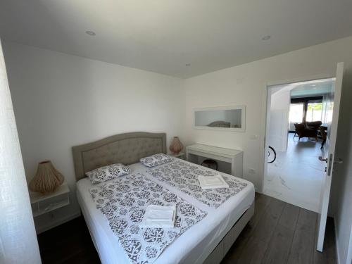 a white bedroom with a bed and a fireplace at Vila Softic Amra in Umag