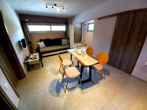 a living room with a table and chairs and a couch at Etoile apartment in Perissa