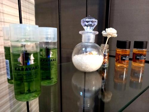 a glass table with a bottle and a vase with sand at Etoile apartment in Perissa