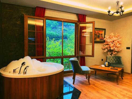 a bathroom with a tub in a room with a window at River Didi Otel in Rize