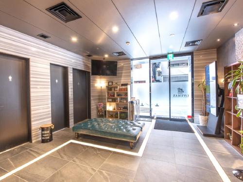 una sala de espera con un banco verde en una tienda en HOTEL LiVEMAX Fukuoka Tenjin, en Fukuoka