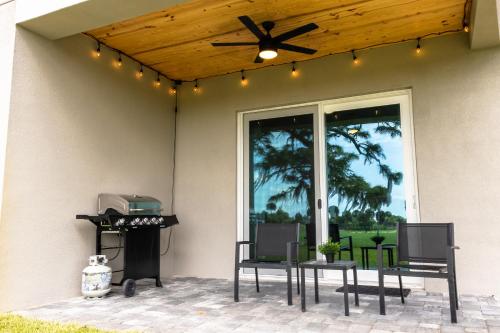 a patio with chairs and a grill with lights at Highest 5 Star Rated Luxury Home 5 Minutes from the Beach! in Melbourne