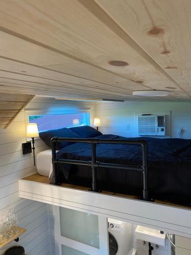 a bedroom with a bed on top of a shelf at The Arkansas Tiny House in Mulberry