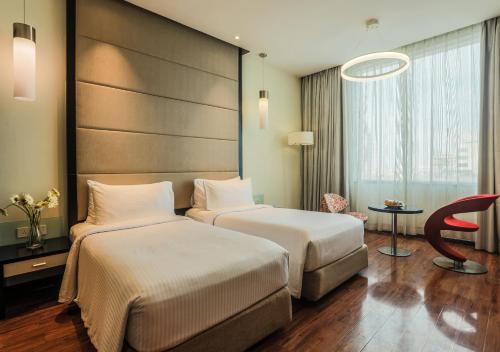 a hotel room with two beds and a chair at E Hotel in Chennai