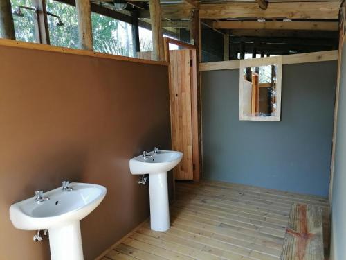 a bathroom with two sinks and a window at Semowi Lodge and Campsites in Mirapene