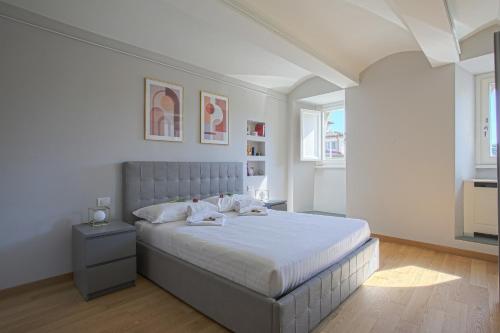 Luxury Suite in Florence - hosted by Sweetstay في فلورنسا: غرفة نوم بسرير كبير في غرفة بيضاء