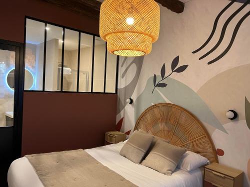 a bedroom with a bed and a chandelier at Hôtel Le Blason in Amboise